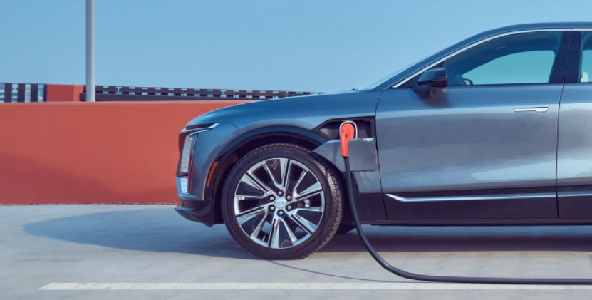 Electric vehicle charging at a modern parking facility, showcasing a sleek black car with a charging cable connected to its port, emphasizing sustainability and the growing trend of electric transportation.